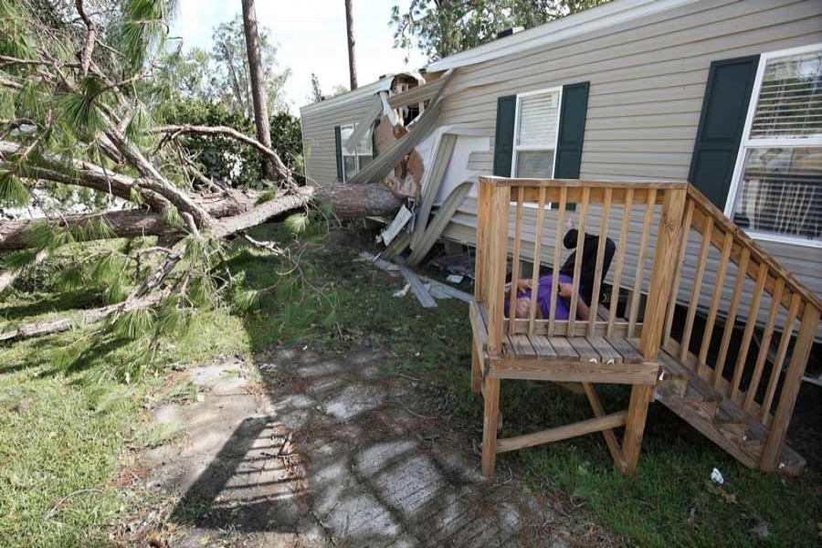 A resident of a mobile home park lies near a home that was destroyed by a falling tree in the wake of Hurricane Irma in Kissimmee, Florida, US September 12. — Reuters