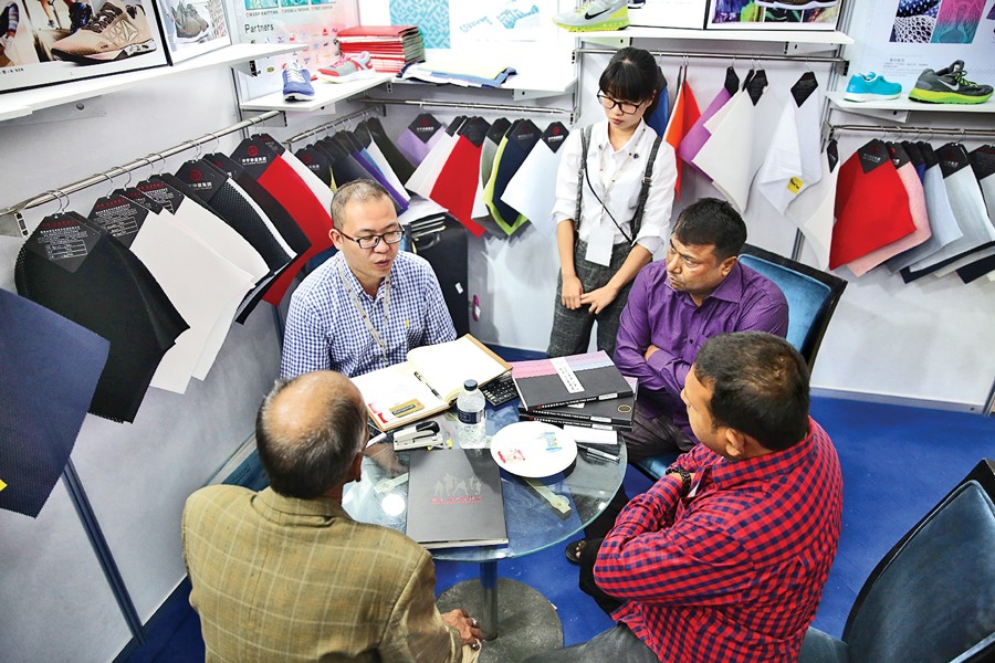 Company officials are negotiating with a buyer representative at a stall of the Bangladesh Leather Footwear & Leathergoods International Sourcing Show 2017, which began in Dhaka Thursday. — FE Photo
