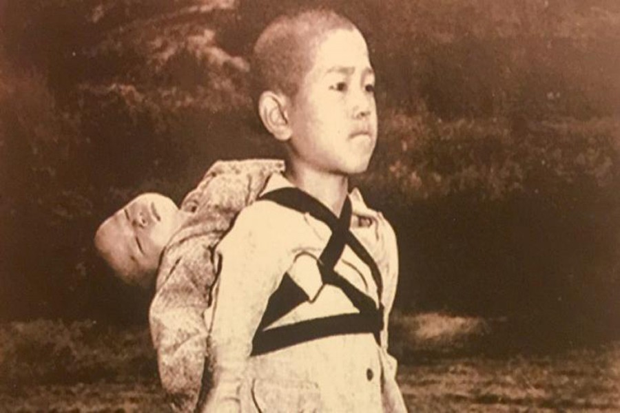 A Japanese child carries the body of his brother. — Internet