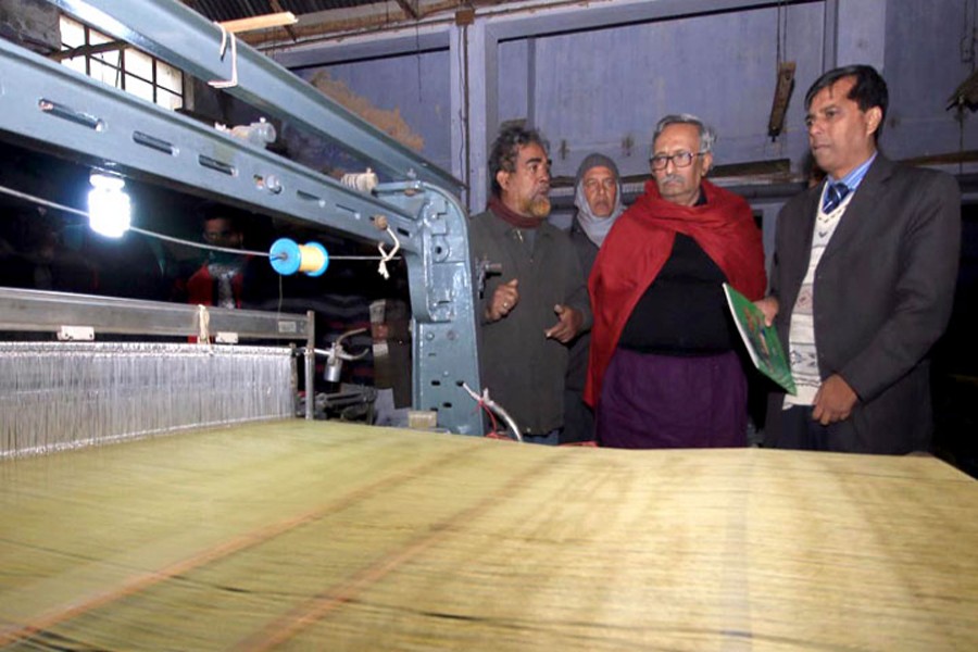 Fazley Hossain Badsha (middle), Member of Parliament of Rajshahi Sadar constituency visits an unit of Rajshahi silk factory on Monday. — FE photo
