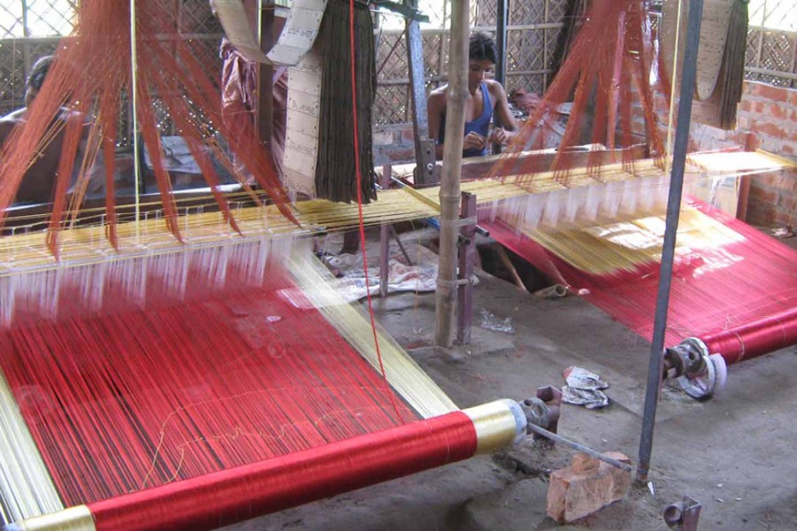 Two artisans weave Benarasi sarees at a factory in Habu Tantipara village under Gangachara upazila of Rangpur on Thursday. — FE Photo