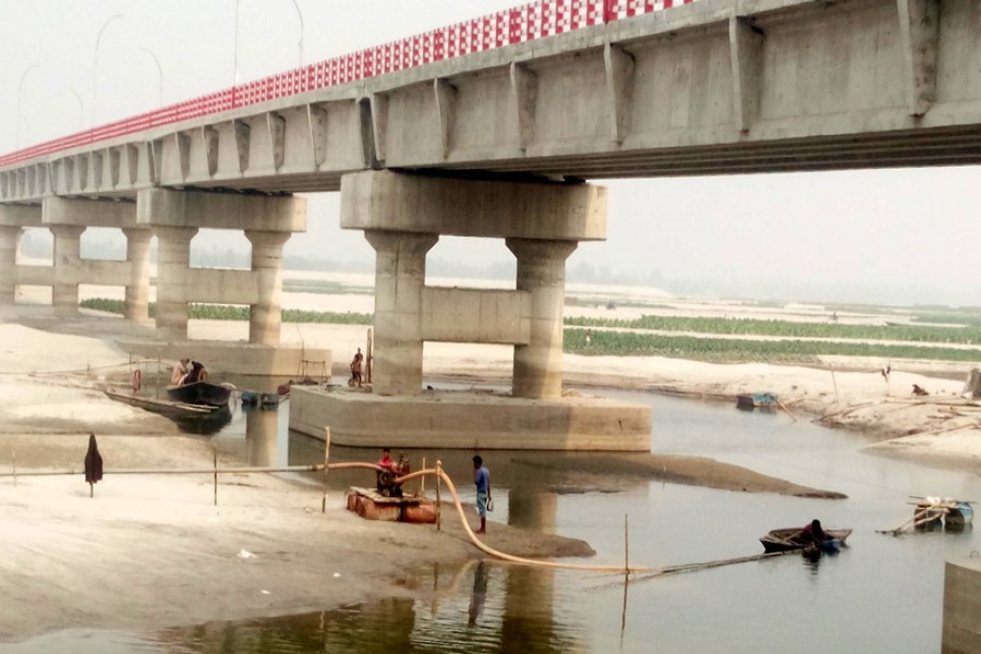 Unauthorised sand lifting from the Teesta poses a threat to the second Teesta Bridge in Mahipur area under Gangachara upazila of Rangpur. — FE Photo