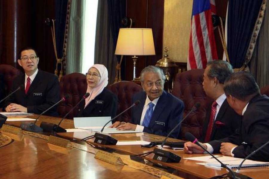 In this photo released by Malaysia Minister of Economic Affairs Azmin Ali’s Office, Malaysian Prime Minister Mahathir Mohamad (third from right) chairs the first cabinet meeting with the new Malaysia cabinet members in Putrajaya, Malaysia on Wednesday, May 23, 2018. Photo Credit: AP