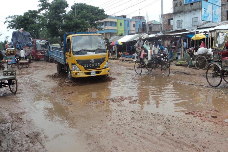 Vehicles plying the dilapidated Bogura-Naogaon road near Goderpara Bazar under Bogura Sadar on Saturday — FE Photo
