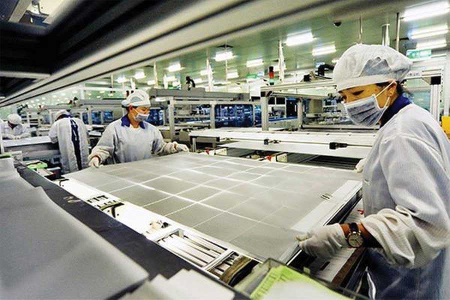 China has issued new standards for photovoltaic (PV) manufacturers. Two women operate on a production line of a solar panel making company in Shangrao, East China's Jiangxi province. — Photo courtesy: China Daily
