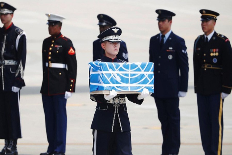A soldier carrying a casket containing the remains of a US soldier killed during the 1950-53 Korean War, after arriving from North Korea at Osan Air Base in Pyeongtaek on Friday — AFP