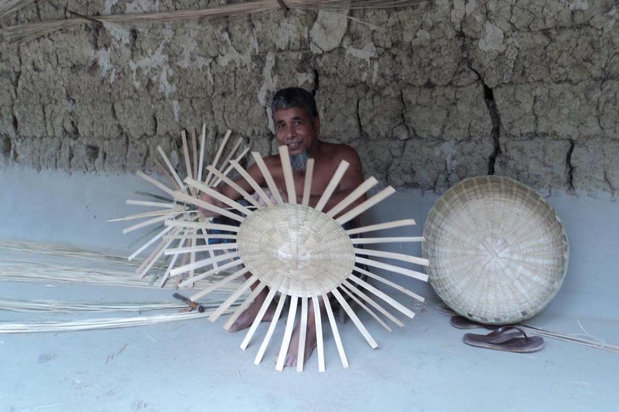 A bamboo craft artisan making different products at his homestead in Shibganj upazila of Bogura on Saturday — FE Photo
