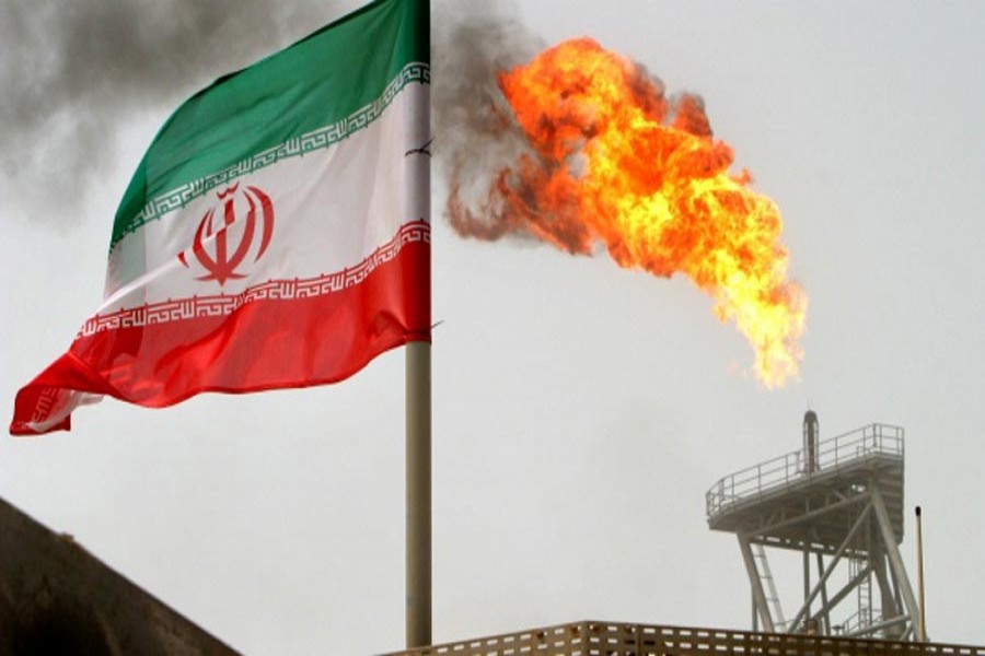 A gas flare on an oil production platform in the Soroush oil fields is seen alongside an Iranian flag in the Persian Gulf, Iran — Reuters