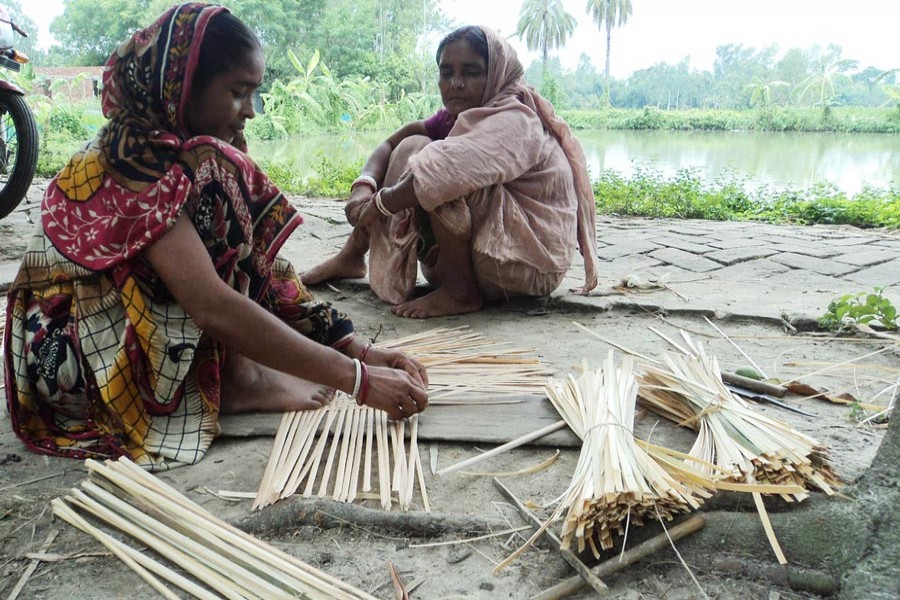 A craftswoman preparing winnowing fan at Paulpara under Dupchanchia upazila of Bogura district — FE Photo