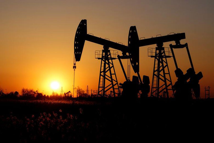 Pumpjacks are seen against the setting sun at the Daqing oil field in Heilongjiang province, China — Reuters