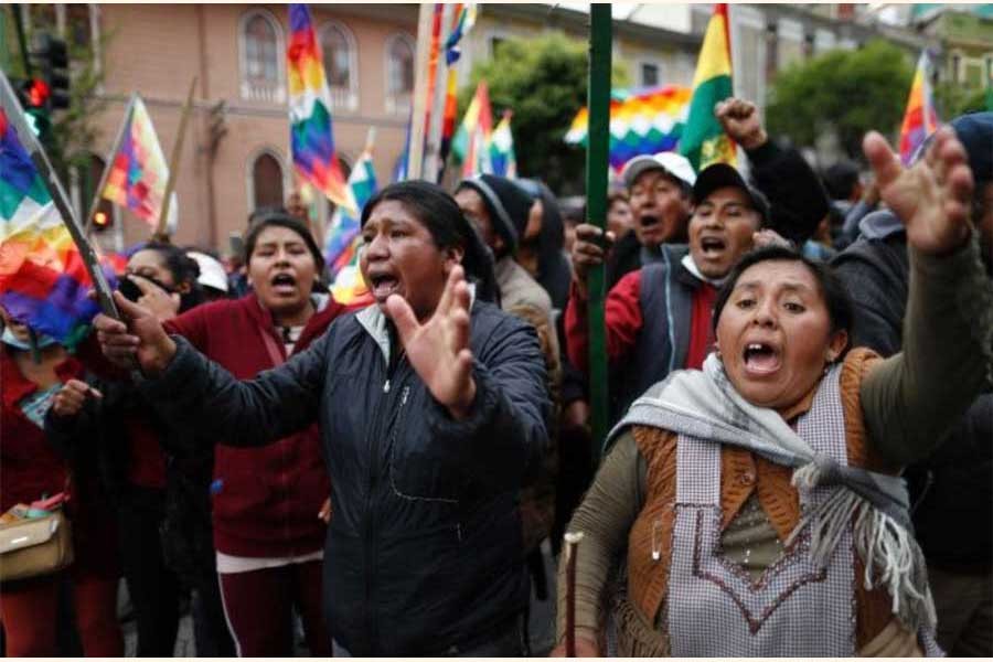 Supporters of former president Evo Morales carry "wiphala" flags that represent indigenous peoples. —Photo: AP