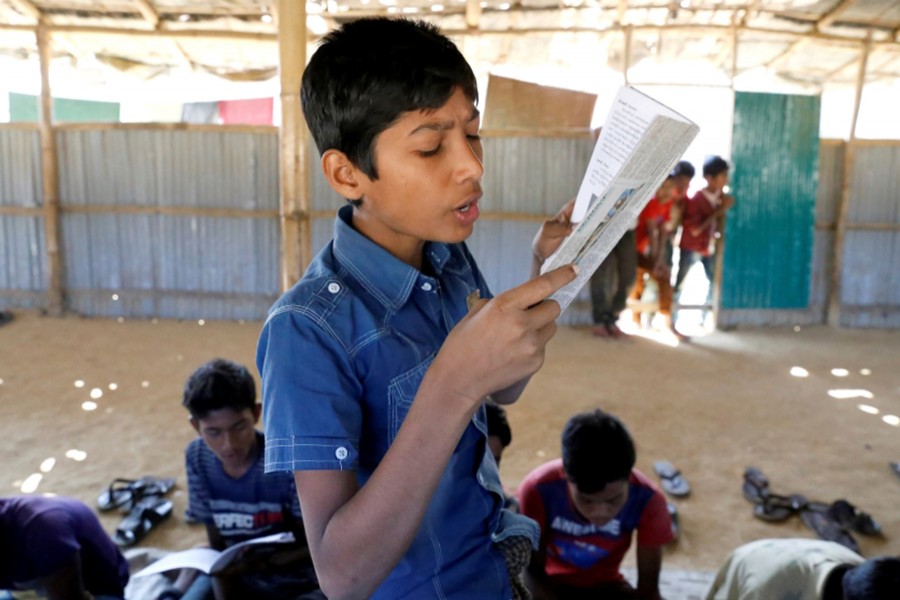 A child read a book in a make-shift school run by Rohingya teachers in Kutupalong refugee camp in Cox’s Bazar, Bangladesh on February 7, 2019 — Reuters/Files