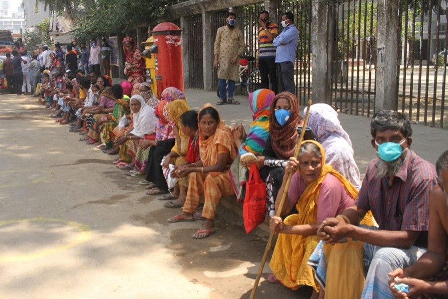 Low-income people waiting to collect relief materials amid a coronavirus shutdown in the country. — UNB Photo