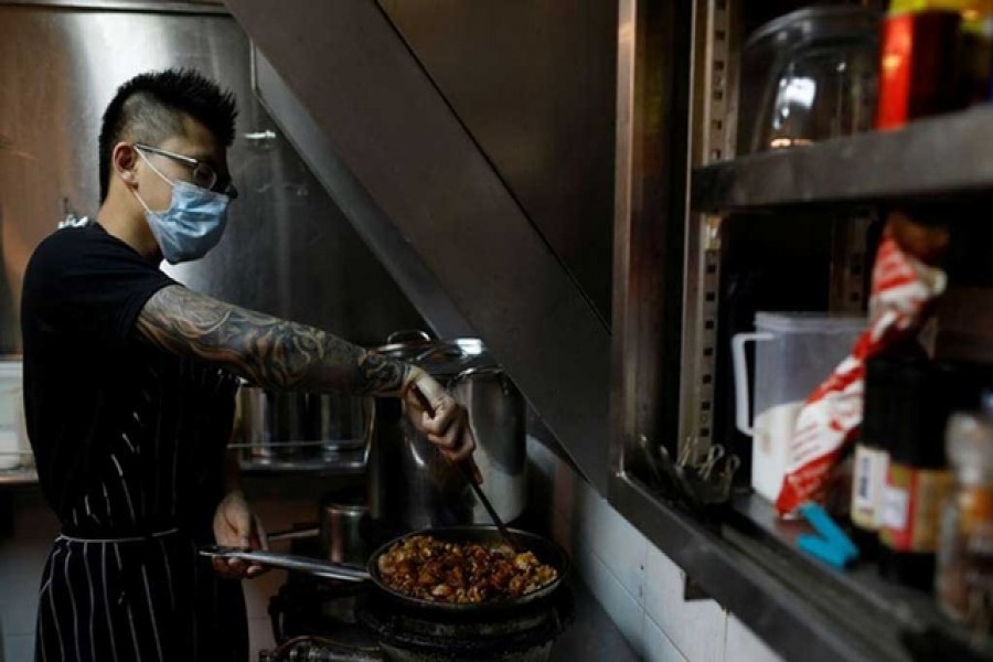 Jason Chua cooks in his stall at Hong Lim Market & Food Centre, amid the coronavirus disease outbreak in Singapore on Apr 27. REUTERS Previous