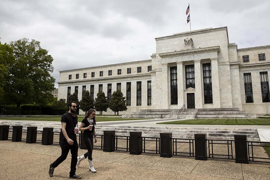 People walk past the U.S. Federal Reserve building in Washington D.C., the United States, May 21, 2020. (Photo by Ting Shen/Xinhua)