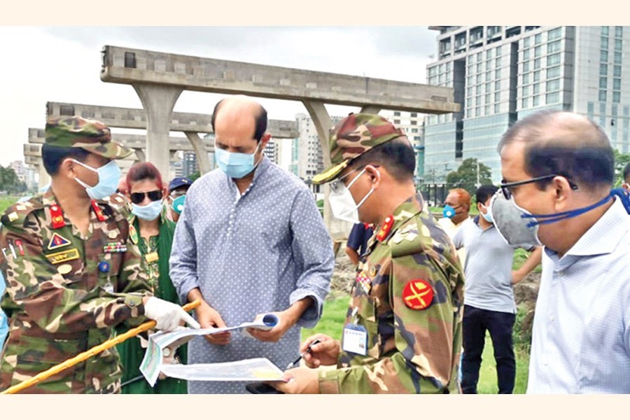 DNCC mayor Atiqul Islam and others looking at the map of the retention canal to be excavated during the mayor's visit to Kha Para, opposite Le Meridien hotel, in the city on Thursday — FE photo