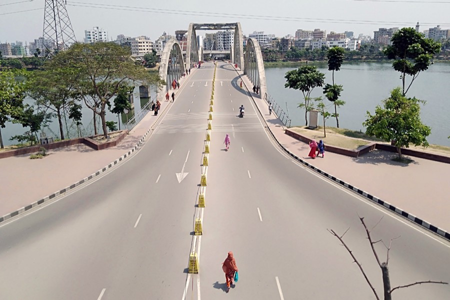 Pedestrians walk along an unusually almost empty street in Hatirjheel area in Dhaka during a lockdown imposed due to the coronavirus — Collected