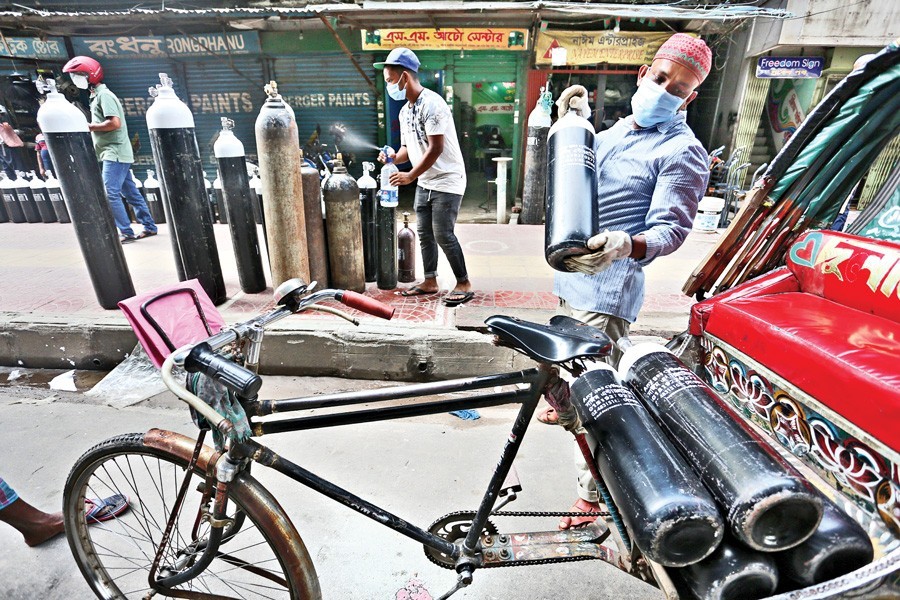 Fire extinguishing cylinders are being used after painting them black and white to fill and supply oxygen for Covid-19 patients, despite the cylinders posing the danger of explosion. The photograph was taken from Maghbazar area in the city on Saturday — FE photo