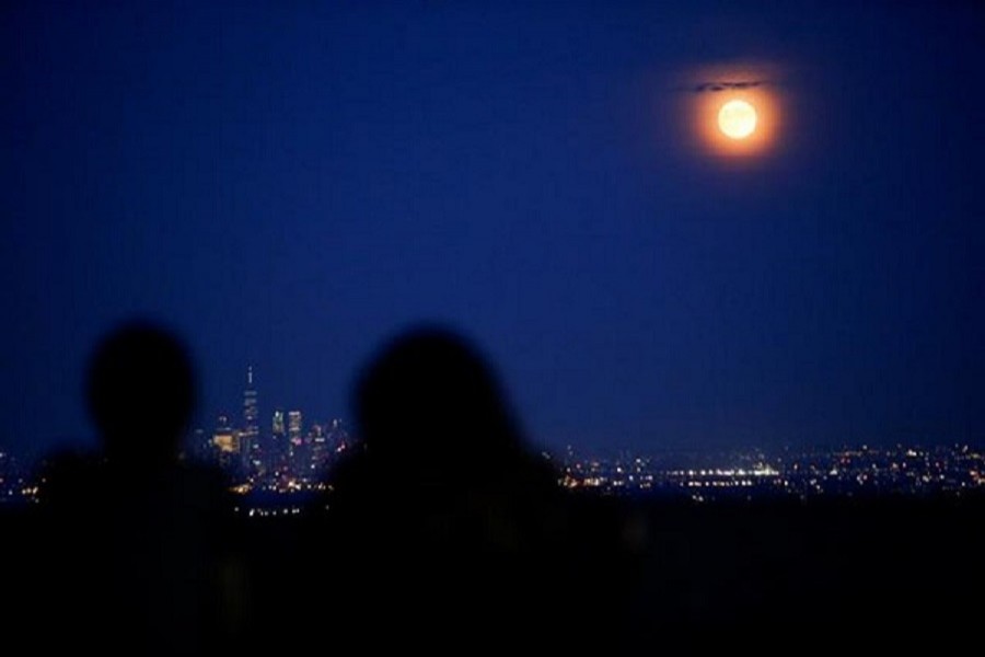 People watch the full moon, known as the "Buck Moon", while it rises over the skyline of New York and One World Trade Center, as seen from West Orange, in New Jersey, US, July 16, 2019 – Reuters/Files