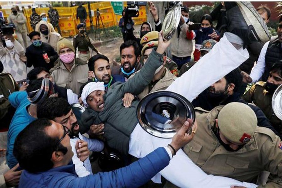 Police officers detain an activist of the youth wing of India's main opposition Congress party during a protest against new farm laws in New Delhi, India Jan 12, 2021. REUTERS
