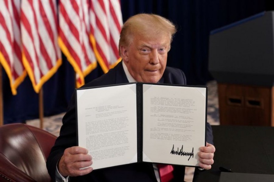 US President Donald Trump shows signed executive orders for economic relief at his golf resort in Bedminster, New Jersey, U.S., August 8, 2020. REUTERS/Joshua Roberts/File Photo