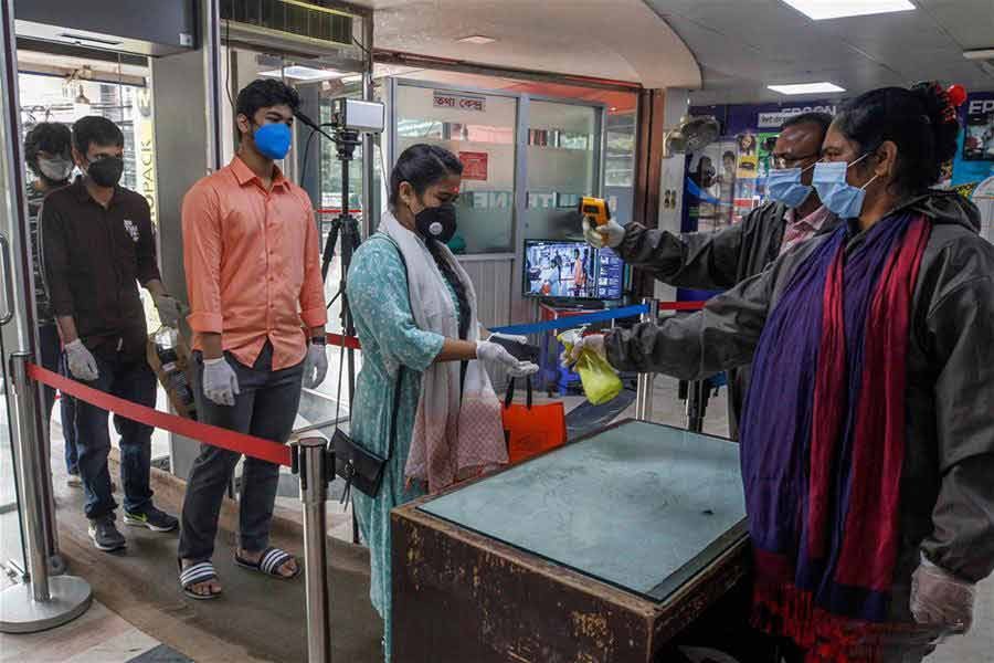 People have their temperature checked while entering a market in Dhaka, Bangladesh on May last —Xinhua