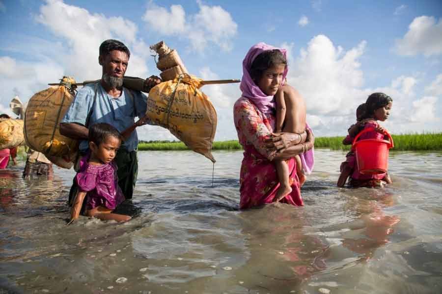 A Rohingya family wades through water crossing the border from Myanmar into Bangladesh. —UNHCR Photo