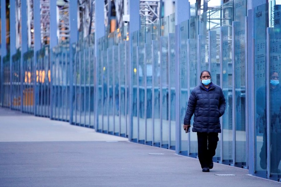 A woman wearing a protective face mask walks along a deserted city bridge during morning commute hours on the first day of a lockdown as the state of Victoria looks to curb the spread of a coronavirus disease (Covid-19) outbreak in Melbourne, Australia on July 16, 2021 — Reuters/Files