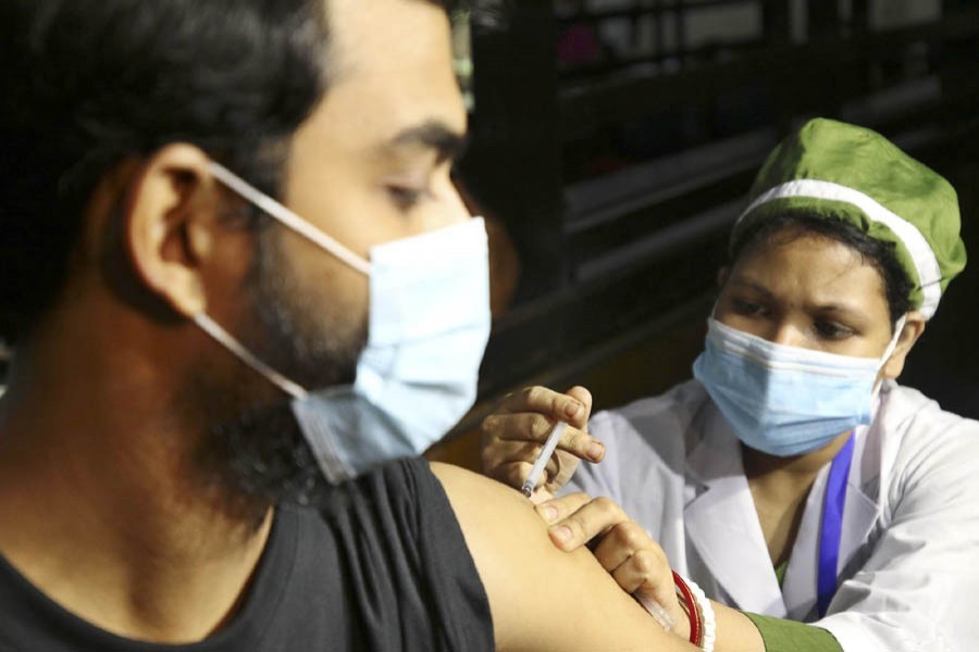 A health worker administers a Covid-19 vaccine shot to a young man at a hospital in Dhaka — Focus Bangla file photo