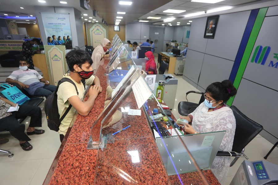 A teller is counting notes of taka at a bank counter in Dhaka. —FE Photo