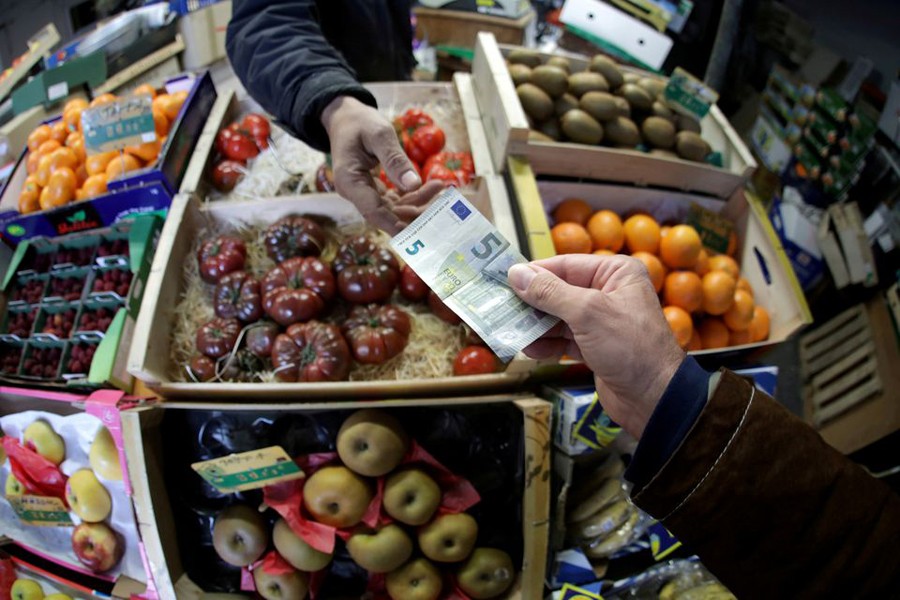 A shopper pays with a euro bank note in a market in Nice, France. —Reuters Photo